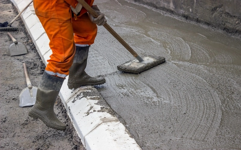 worker working on sidewalk concrete